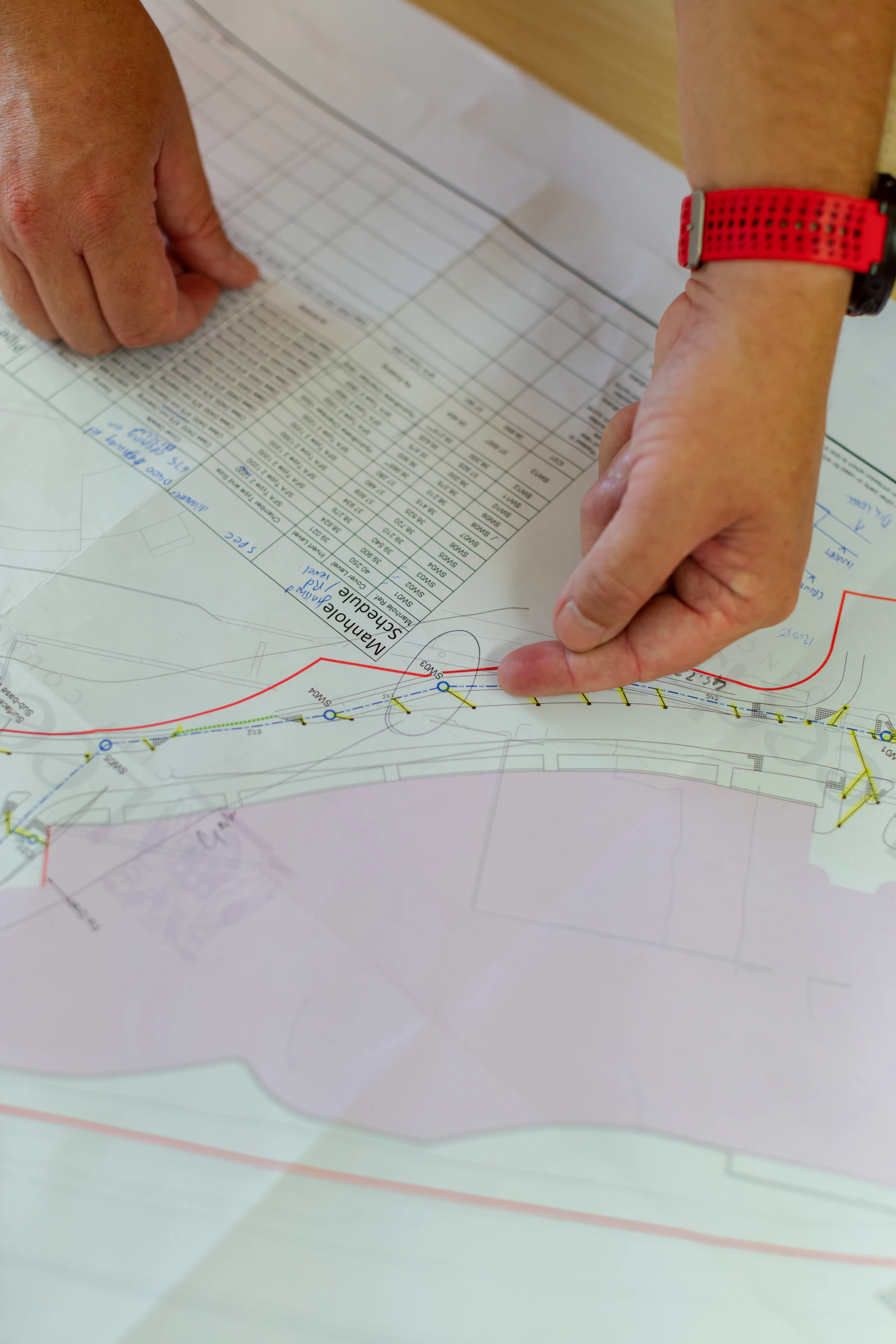 Main suivant un tracé de réseau sur un plan d'exécution.