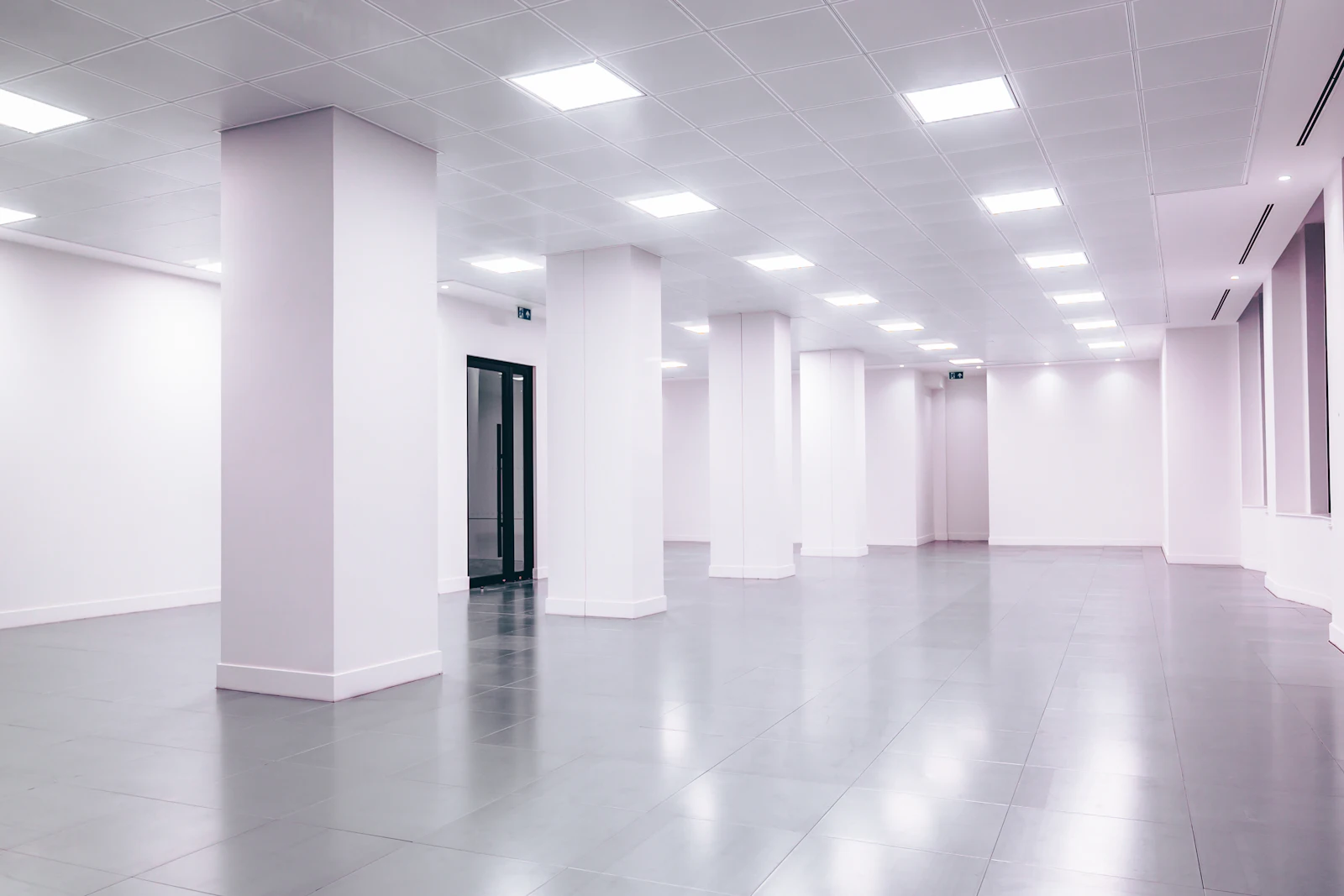 Plateau de bureaux neuf avec éclairage encastré au plafond.